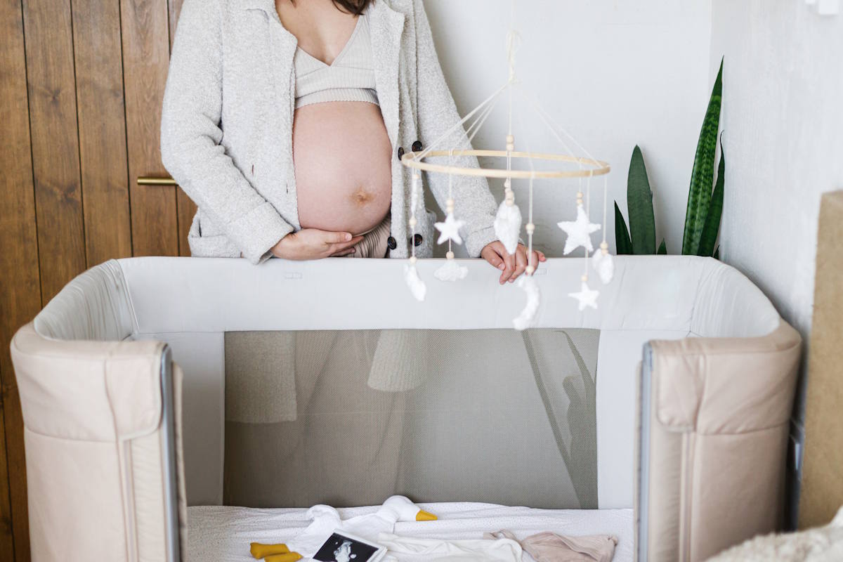 Une femme enceinte qui installe un berceau en prévision de cododo
