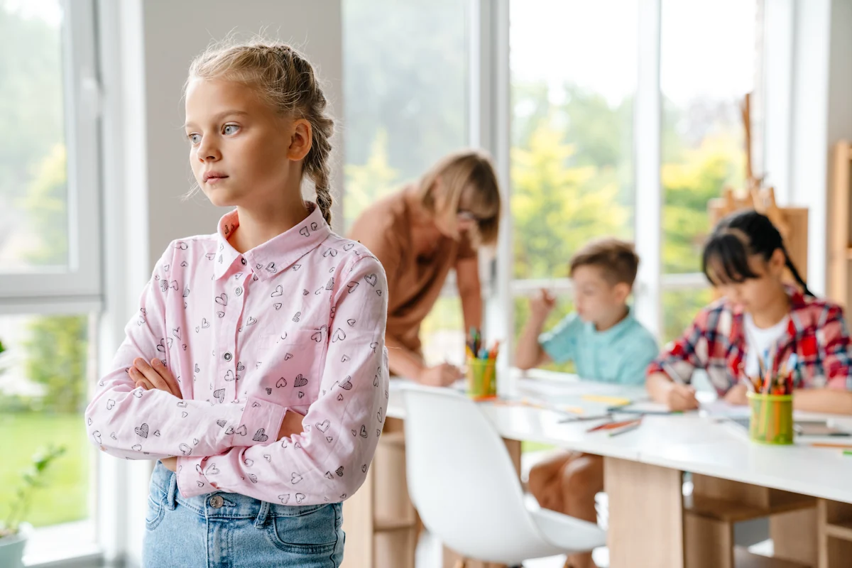 Une petite fille qui se tient à l'écart d'un groupe de copain