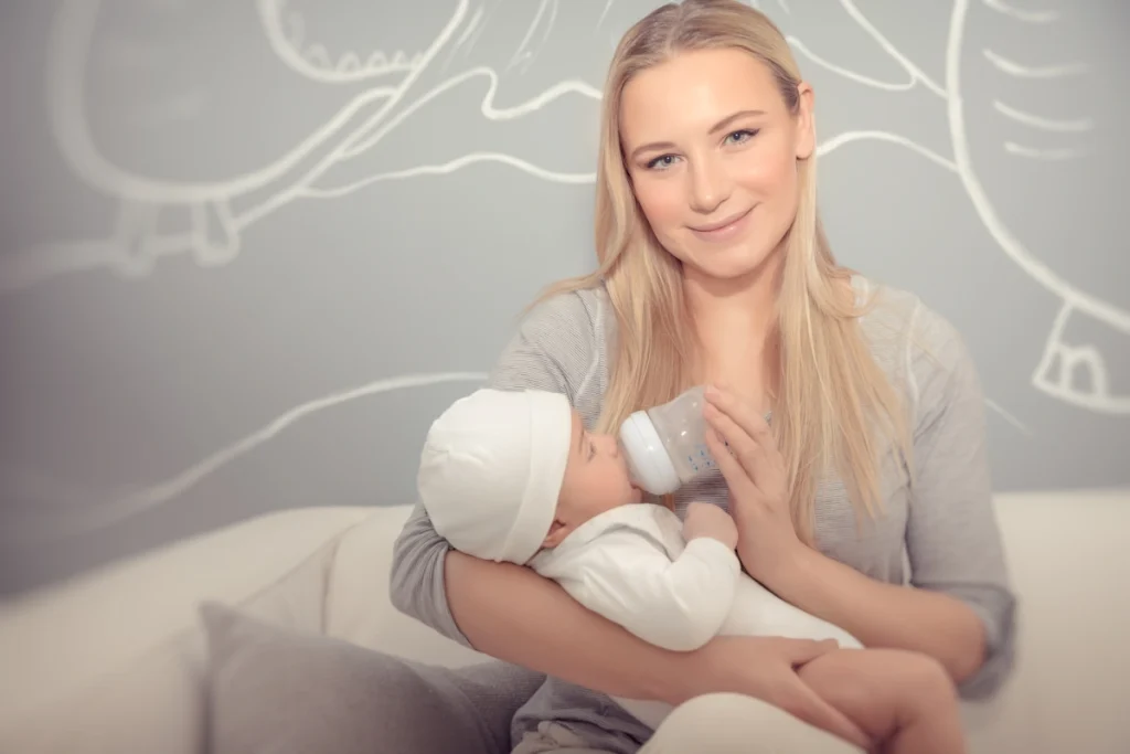 Une femme qui allaite un bébé avec un biberon de lai maternel