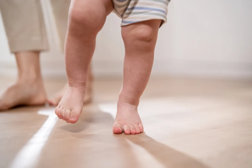 Un bébé qui marche sur la pointe des pieds