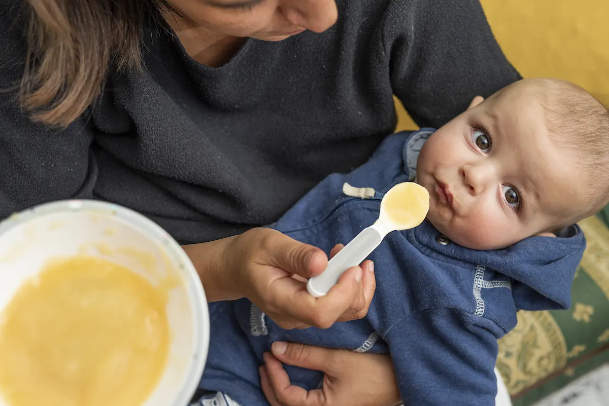 une maman qui donne de la purée à bébé