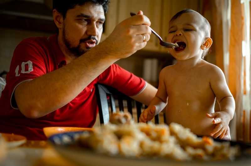 Papa qui donne à manger à son fils