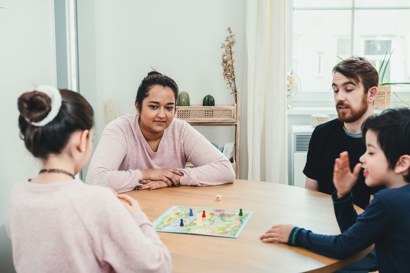 Famille jouant à un jeu de société à la maison