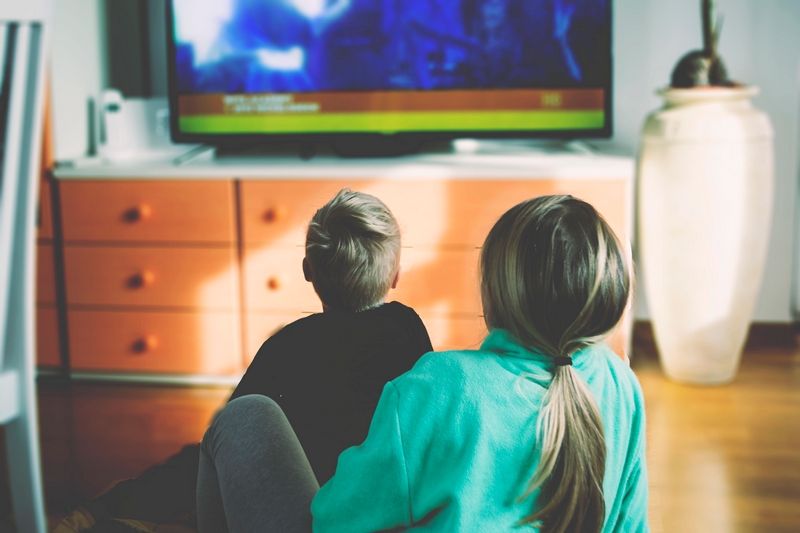 Enfants assis par terre regardant un écran