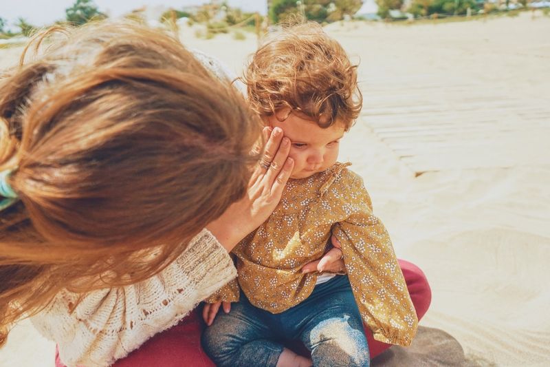 Maman jouant avec son bébé dans le sable