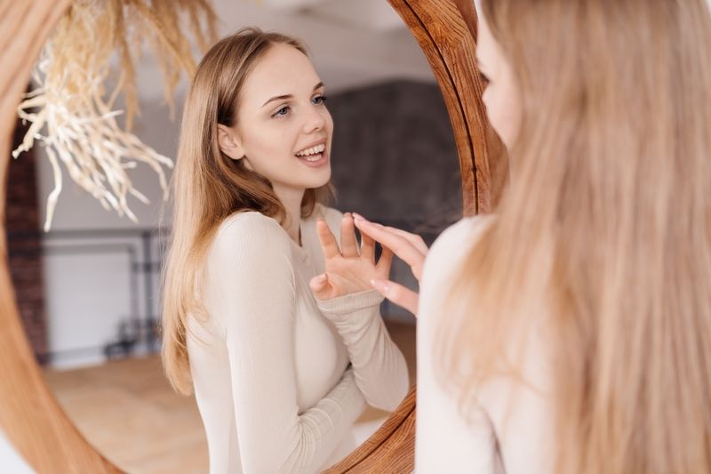 Jeune femme retrouvant confiance devant son miroir